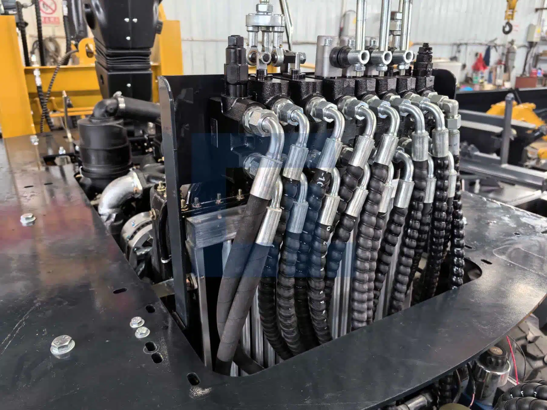 Close-up of HIGHLAND HEAVY MACHINERY HILT 50 backhoe loader main control valve assembly, showing precision manifold, hydraulic ports, and heavy-duty solenoids for professional excavation performance