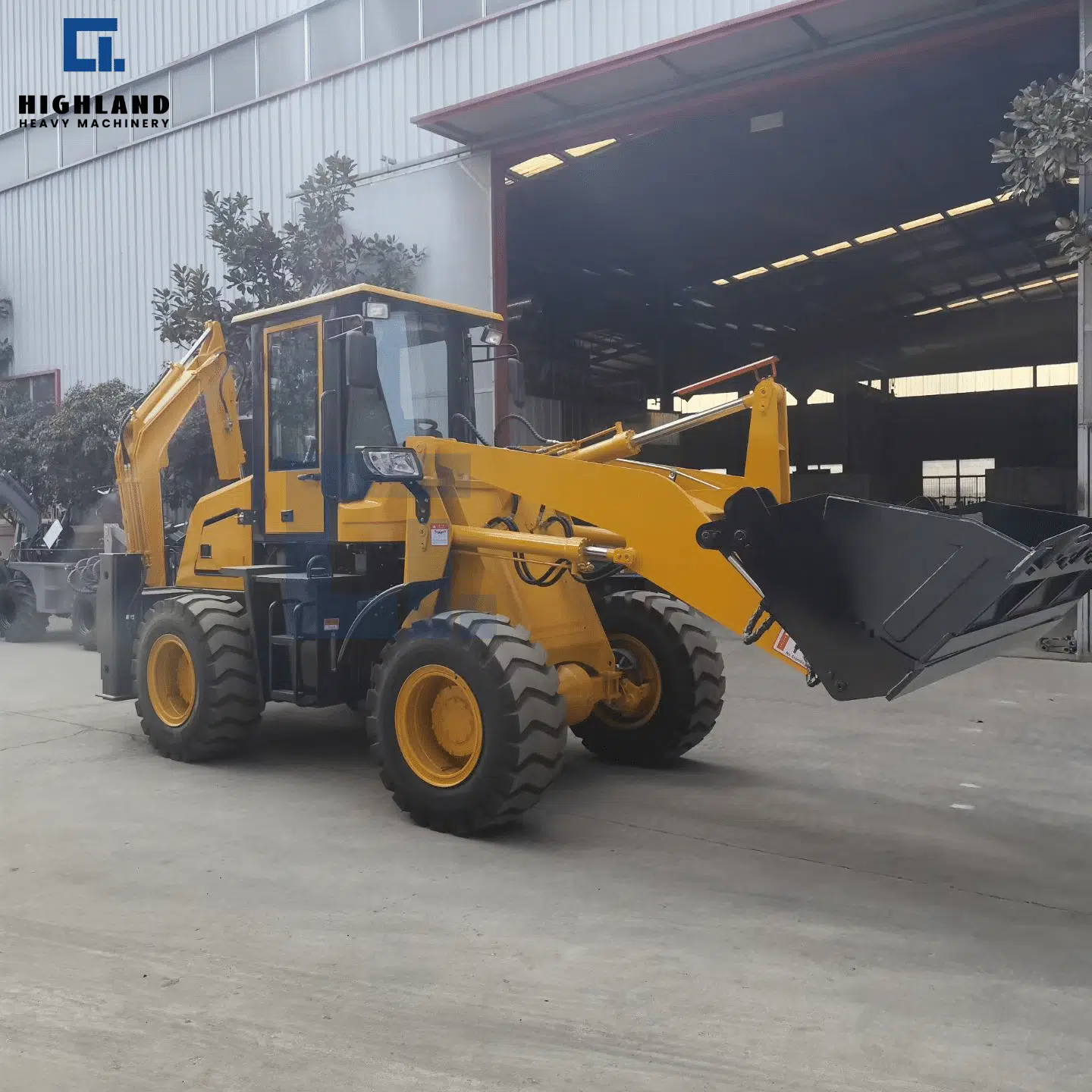 HIGHLAND HEAVY MACHINERY HILT 80 front wheel loader with large bucket slightly raised, parked outside factory, ready for everyday material loading and general earthmoving tasks