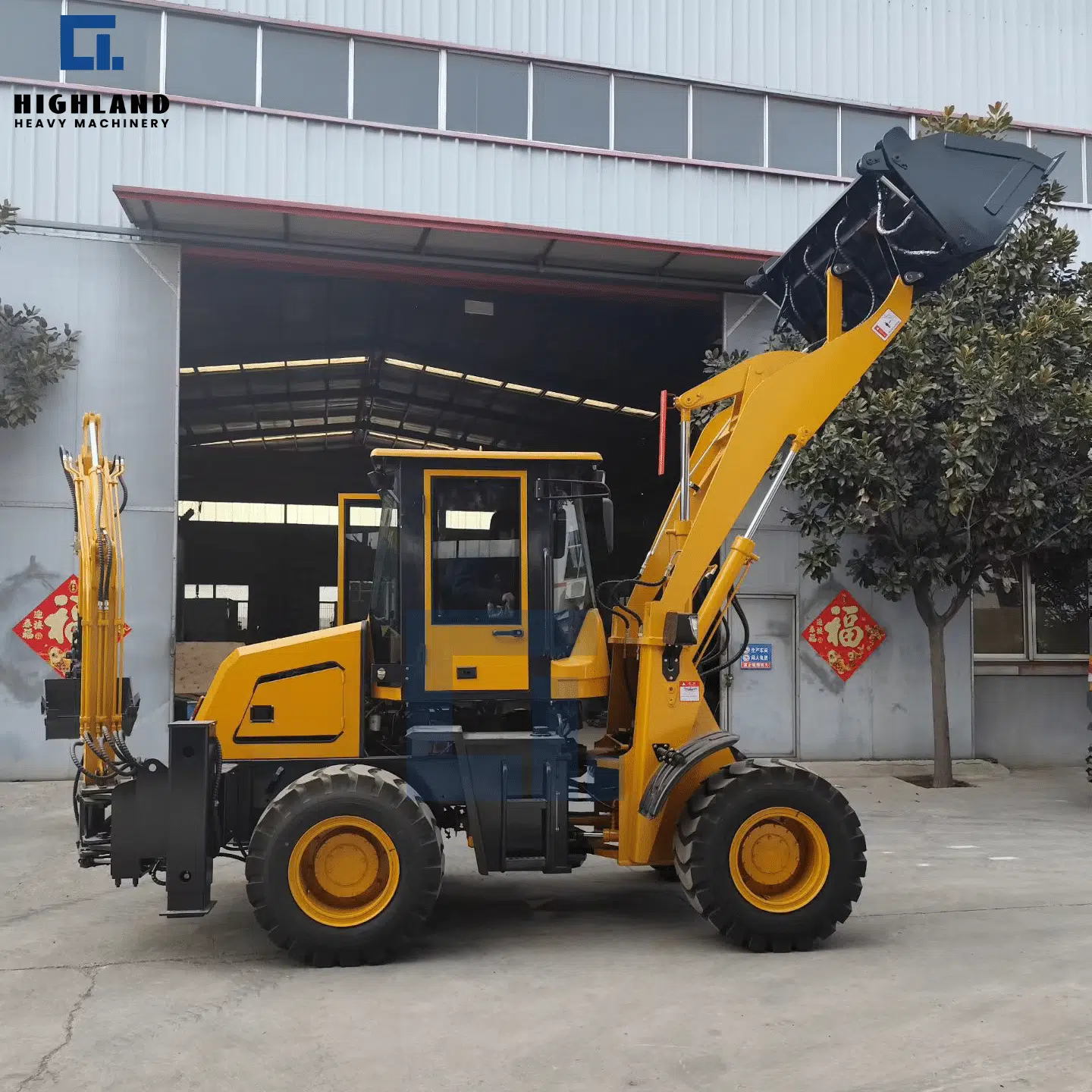HIGHLAND HEAVY MACHINERY HILT 80 backhoe loader with front loader bucket raised to maximum height, demonstrating impressive dump clearance and stacking capability near factory entrance