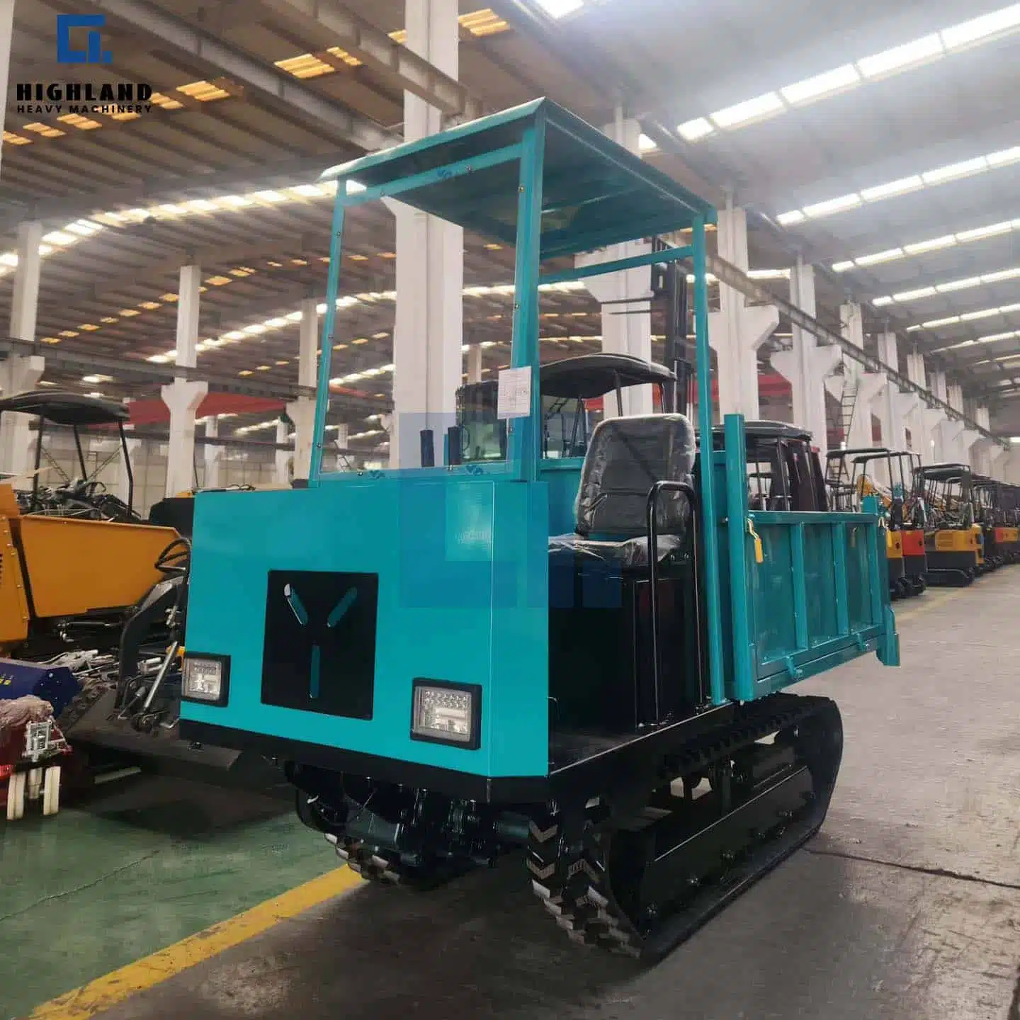 Highland Heavy Machinery blue HILD 2.0 crawler dumper with enclosed operator cabin, parked in factory for all-weather construction and farm material transport