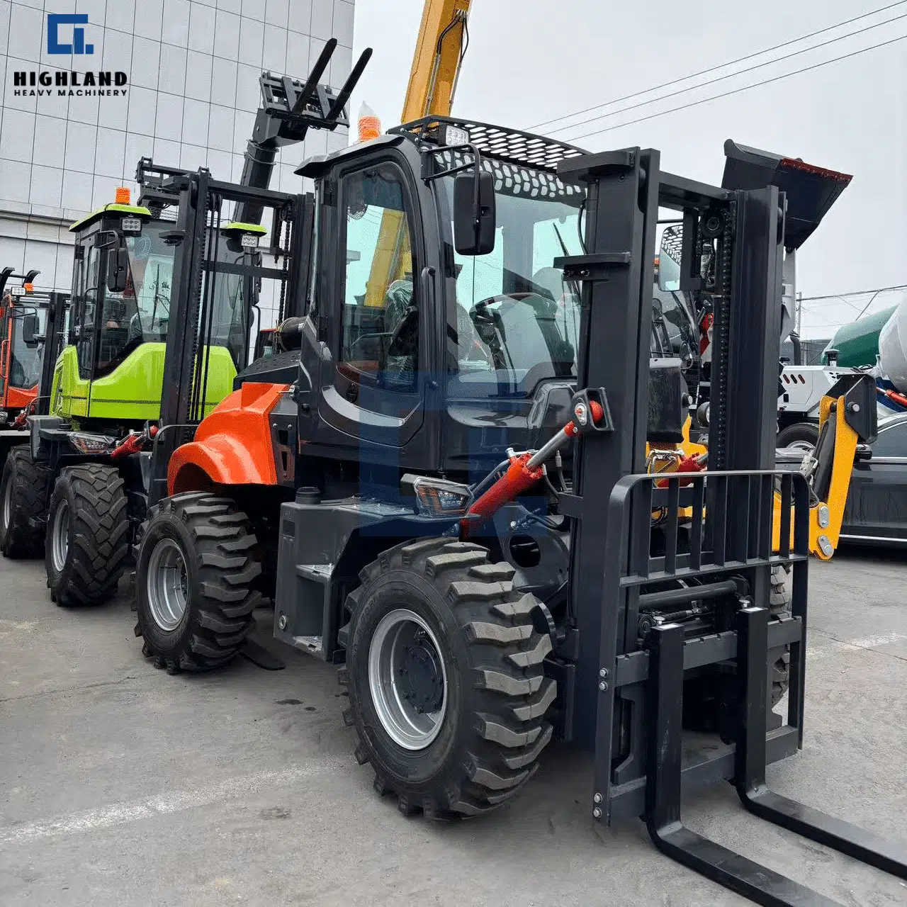 HIGHLAND HEAVY MACHINERY 5T articulated rough terrain forklift in charcoal grey with a solid black mast, enclosed cabin, and large pneumatic tires, parked in a multi-vehicle industrial yard.