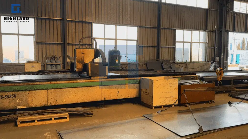 HIGHLAND HEAVY MACHINERY industrial laser cutting machine processing large metal sheets inside the factory, demonstrating precision manufacturing capabilities for heavy equipment production.